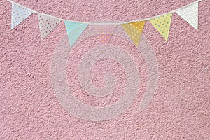 Flag garland on pink cement wall texture background