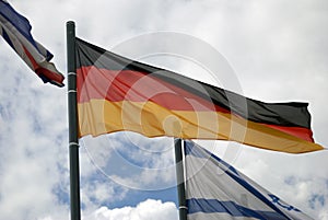 Flag of Germany, blue sky with clouds background