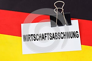 On the flag of Germany lies a business card with the inscription - economic slowdown