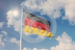 Flag of Germany, National symbol waving against cloudy, blue sky, sunny day
