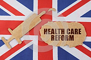 On the flag of Great Britain, the figure of a syringe and cardboard with the inscription - HEALTH CARE REFORM