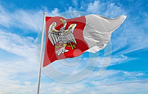 flag of Greater Poland Voivodeship, wojewodztwo wielkopolskie , Poland at cloudy sky background on sunset, panoramic view. Polish