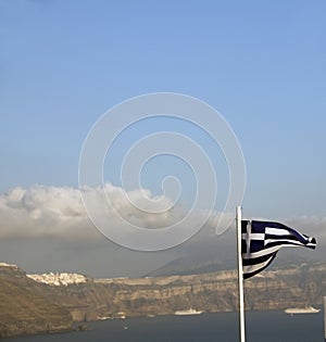 Flag Greece flying over caldera Oia Santorini