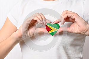 Flag of Guyana in the shape of a heart in the hands of a girl. Love Guyana.