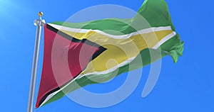 Flag of Guyana waving at wind in slow in blue sky, loop