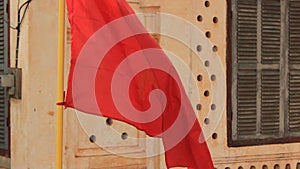 flag hanging from a deteriorating communist style home in Suvannakhet