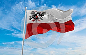 flag of Hansestadt Lubeck at cloudy sky background on sunset, panoramic view. Federal Republic of Germany. copy space for wide photo