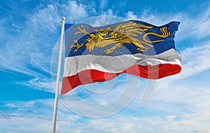 flag of Hansestadt Rostock at cloudy sky background on sunset, panoramic view. Federal Republic of Germany. copy space for wide photo