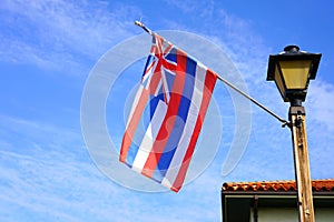 Flag of Hawaii floating on a blue sky