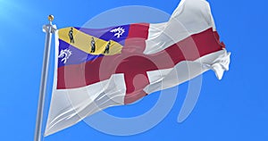 Flag of Herm waving at wind in slow in blue sky, loop