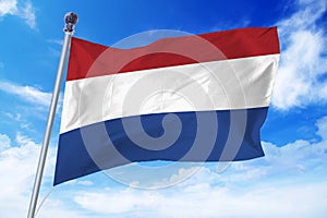 Flag of Holland developing against a clear blue sky