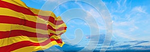 flag of Ibero-Romance peoples Catalans at cloudy sky background, panoramic view. flag representing ethnic group or culture,