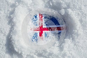 Flag of Iceland covered with snow and ice.