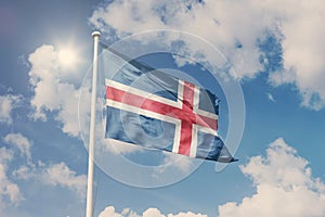 Flag of Iceland, National symbol waving against cloudy, blue sky, sunny day