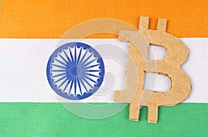 The flag of India has a bitcoin symbol cut out of cardboard.