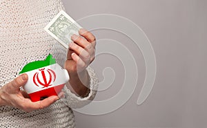 Flag of Iran on money bank in Irani woman hands. Dotations, pension fund, poverty, wealth, retirement concept photo