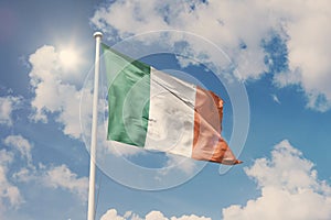 Flag of Ireland, National symbol waving against cloudy, blue sky, sunny day