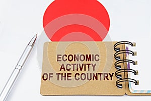 On the flag of Japan lies a pen and a notebook with the inscription - economic activity of the country