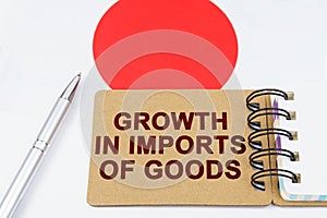 On the flag of Japan lies a pen and a notebook with the inscription - growth in imports of goods