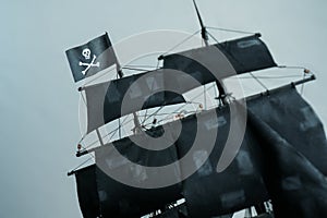 Flag Jolly Roger Skull and bones of Pirate ship model Black pearl made of plywood, blurred patched sails and ropes