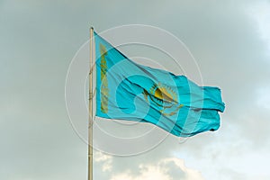 Flag of Kazakhstan on sky background. Waving flag of Republic of Kazakhstan