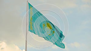 Flag of Kazakhstan on sky background. Waving flag of Republic of Kazakhstan.