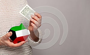 Flag of Kuwait on money bank in Kuwaiti woman hands. Dotations, pension fund, poverty, wealth, retirement concept