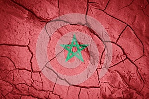 Flag of Marocco. Maroccan symbol. Flag on the background of dry cracked earth.