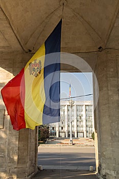 Flag of Moldova waiving under the Triumphal Arch Arcul de Triumf in dowtown Chisinau Kishinev, in front of Government House