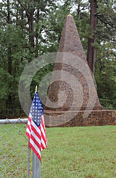 a flag is near an old stone monument with a fence around it