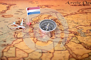 Flag of the Netherlands, compass and airplane on the world map