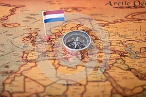 Flag of the Netherlands and compass on the world map