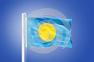 Flag of Palau flying against a blue sky