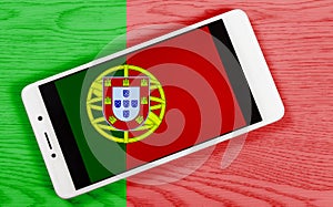 Creative Portuguese Flag Consisting of a Smartphone over a Wooden Background photo