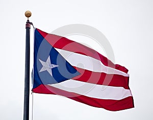 Flag of Puerto Rico waving against blue sky