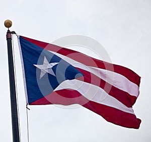 Flag of Puerto Rico waving against blue sky