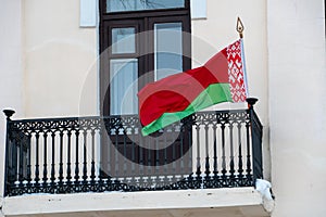 the flag of the Republic of Belarus on the balcony of the state building. Rally in Minsk. An illegitimate government. Riots in