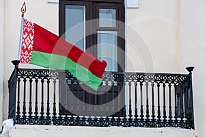 the flag of the Republic of Belarus on the balcony of the state building. Rally in Minsk. An illegitimate government. Riots in