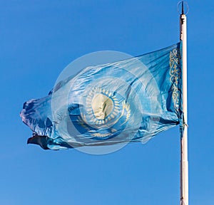 Flag of the Republic of Kazakhstan waving in the wind against the blue sky