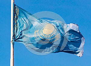 Flag of the Republic of Kazakhstan waving in the wind against the blue sky