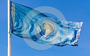 Flag of the Republic of Kazakhstan waving in the wind against the blue sky