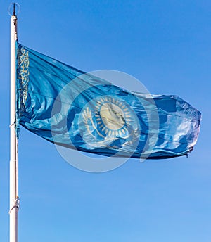 Flag of the Republic of Kazakhstan waving in the wind against the blue sky