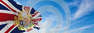 flag of Royal Arms of England on United Kingdom at cloudy sky background on sunset, panoramic view. united kingdom of great