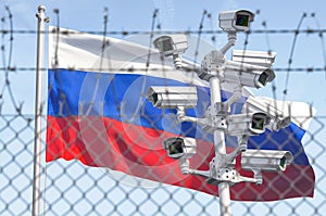 Flag of Russia behind barbed wire fence and cctv cameras. Concept of sanctions, dictatorship, discrimination and violation of