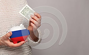 Flag of Russia on money bank in Russian woman hands. Dotations, pension fund, poverty, wealth, retirement concept