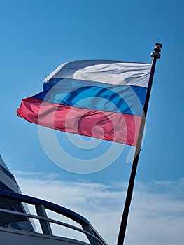 the flag of the Russian Federation against the background of a blue sky.