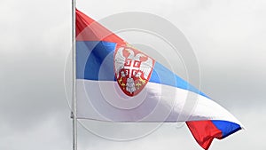 The flag of Serbia waves in the wind in slow motion