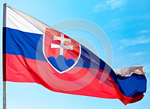 Vlajka Slovenska proti modrej oblohe