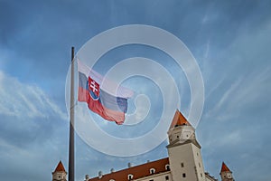 Flag of Slovakia with fragments of Bratislava Castle against the sky