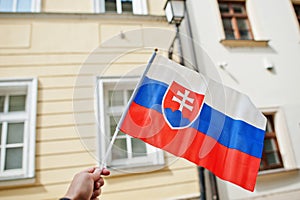 Flag of Slovakia in hand against street of Bratislava